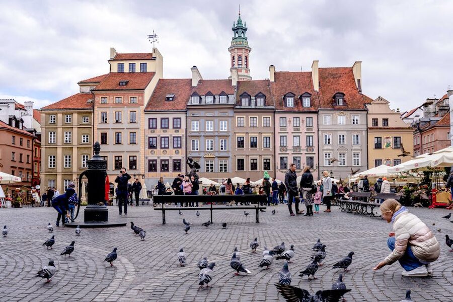 Old Town Square in Warsaw with people and pigeons