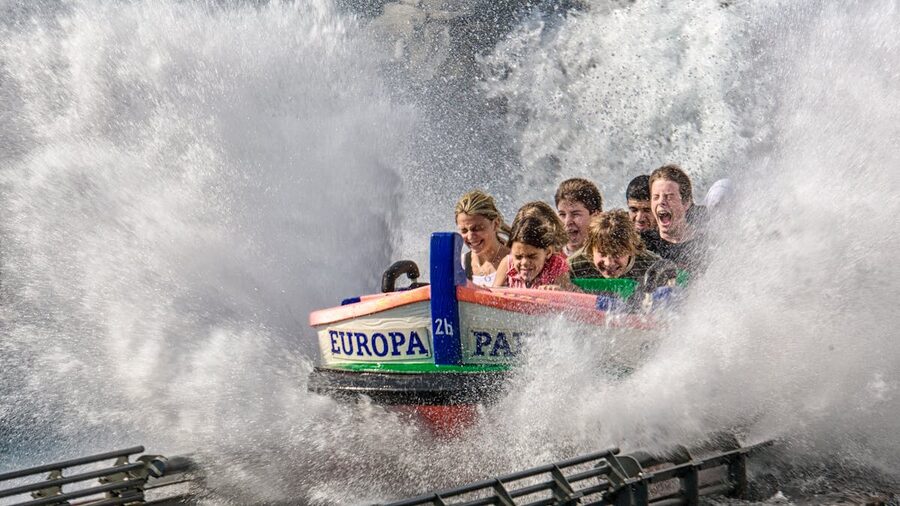 Group of riders getting splashed on a water ride at a theme park