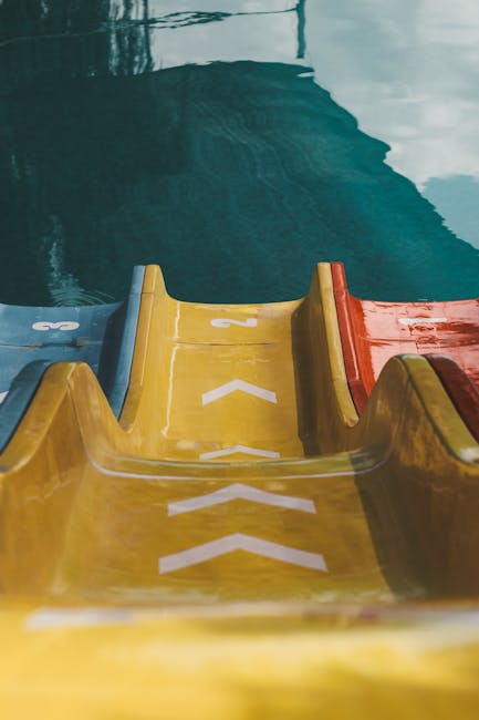 Colorful water slides at a water park twisting through tropical scenery