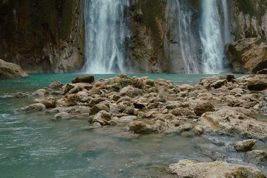 Waterfall cascading into a turquoise pool surrounded by rocks