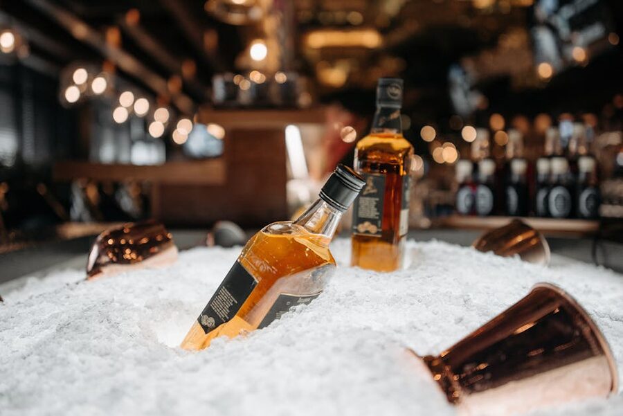 Whiskey bottles on ice bar in warm light