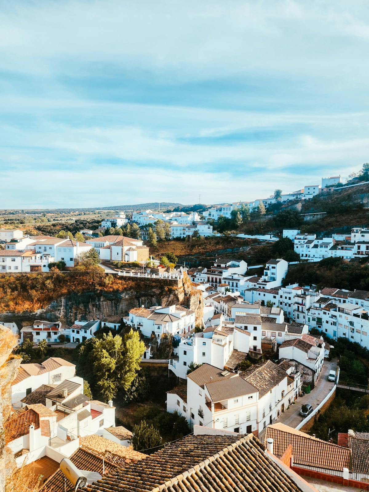 Aerial view of whitewashed villages spread across green hills in Andalusia Spain