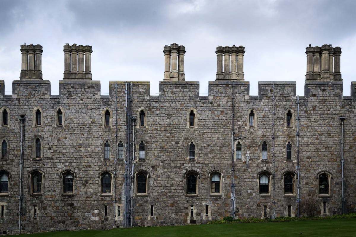 Majestic stone facade of Windsor Castle against cloudy sky