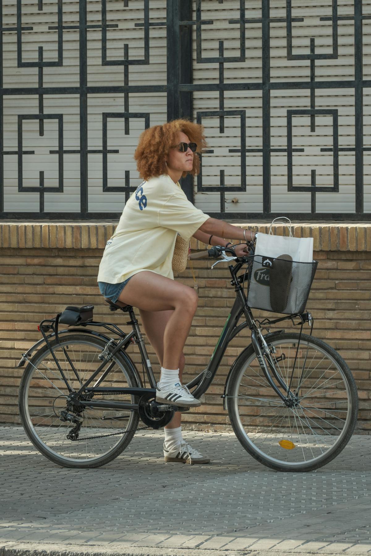 Casual woman cycling in sunny urban environment during summer