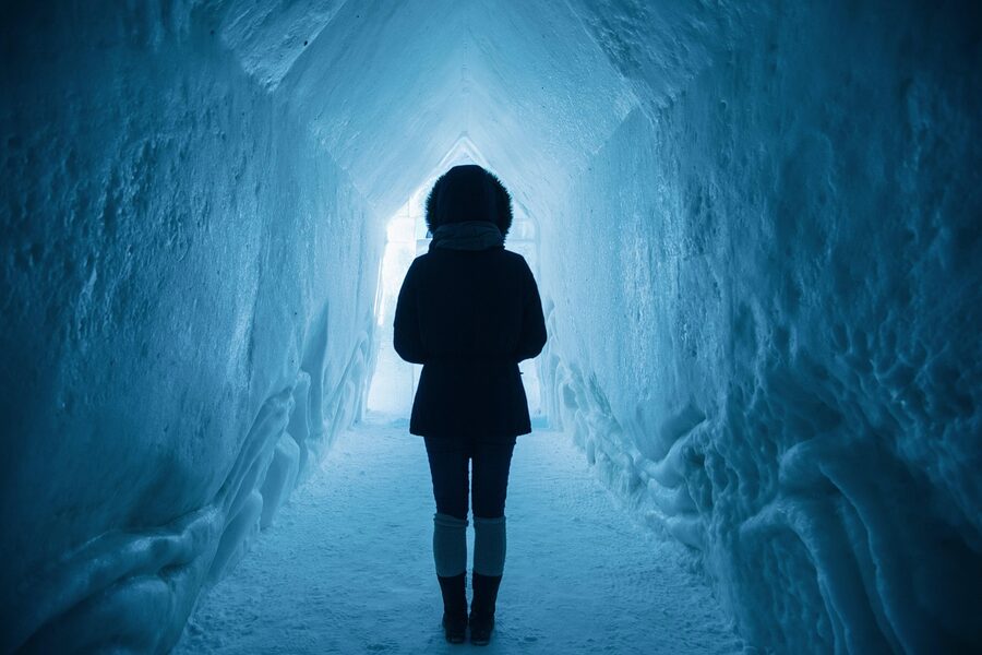 Woman exploring ice cave tunnel Iceland