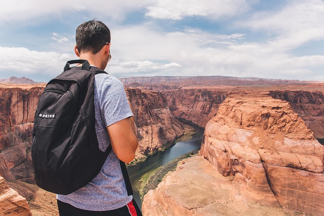 Backpacker looking over a vast gorge landscape with dramatic cliff edges