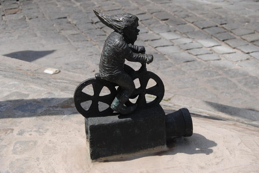 Wroclaw dwarf with tourists on the dwarf hunt