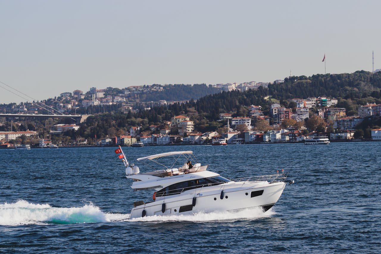 Luxury yacht sailing along the Bosphorus with Istanbul's skyline in the background