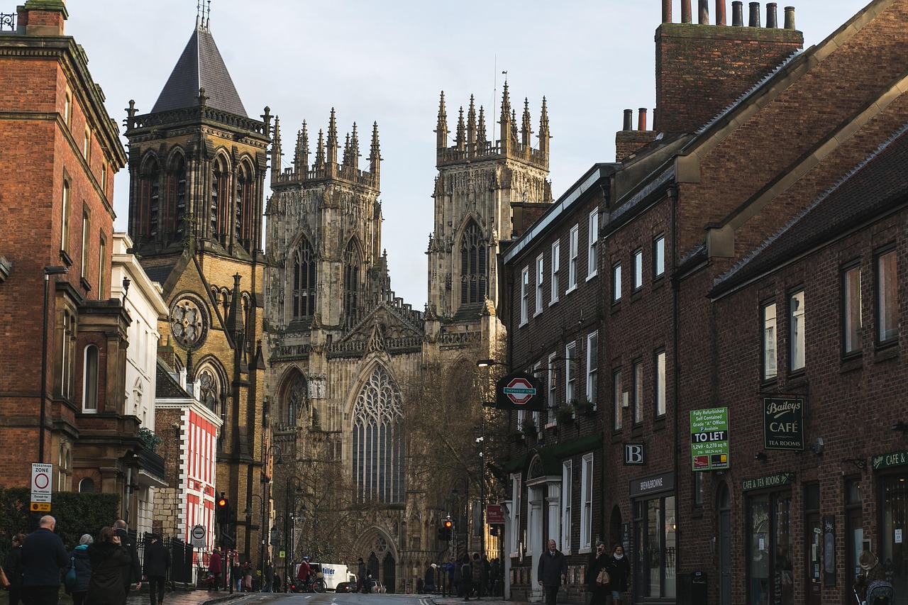 People walking along a street with York Minster towers rising in the background
