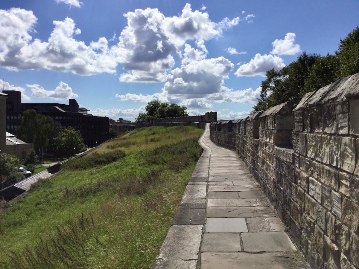 Ancient stone city walls of York stretching into the distance on a bright summer day