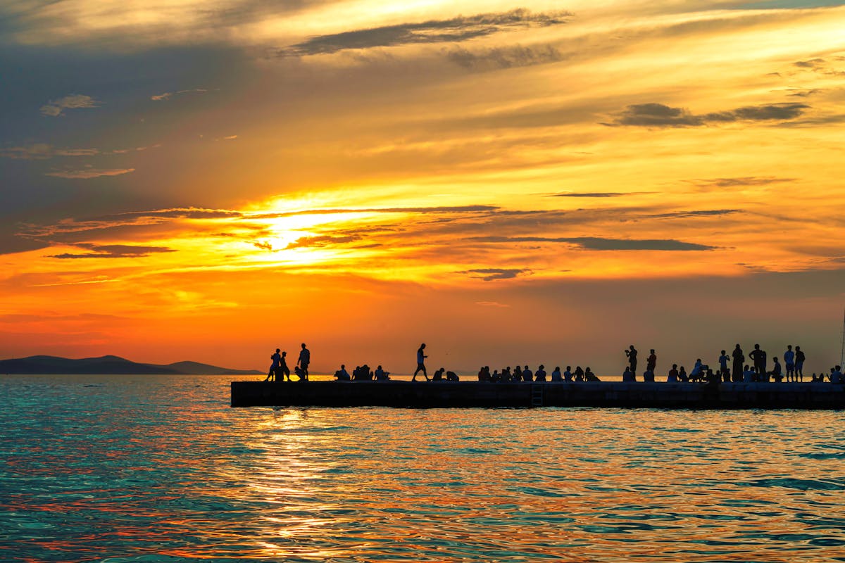 Vibrant sunset with people on pier in Zadar