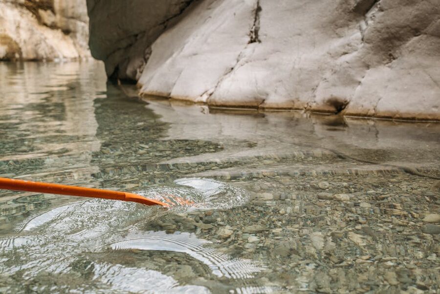 Orange kayak paddle in clear water