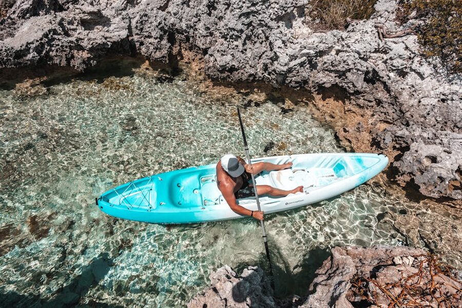 Kayaker in turquoise waters rocky landscape