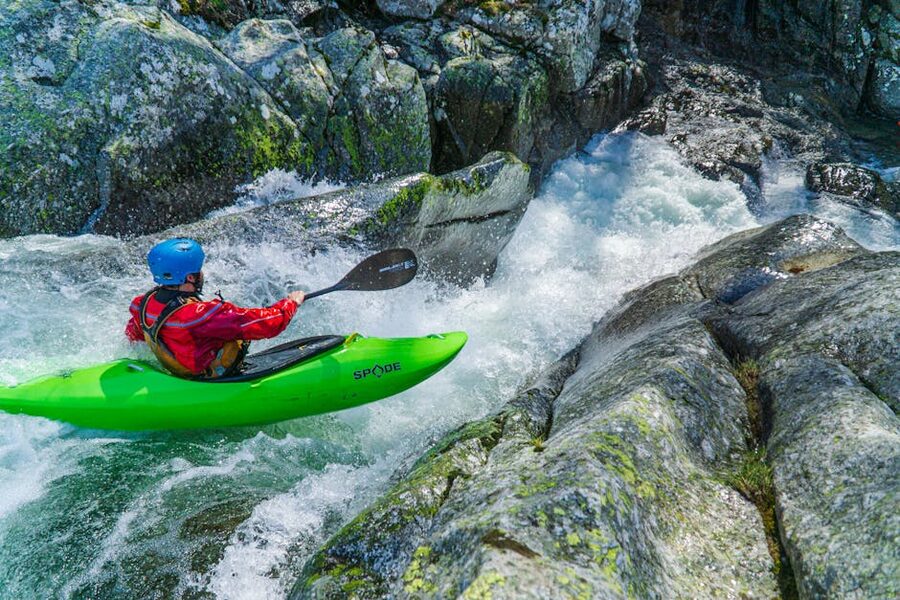 Kayaker in bright green kayak on water
