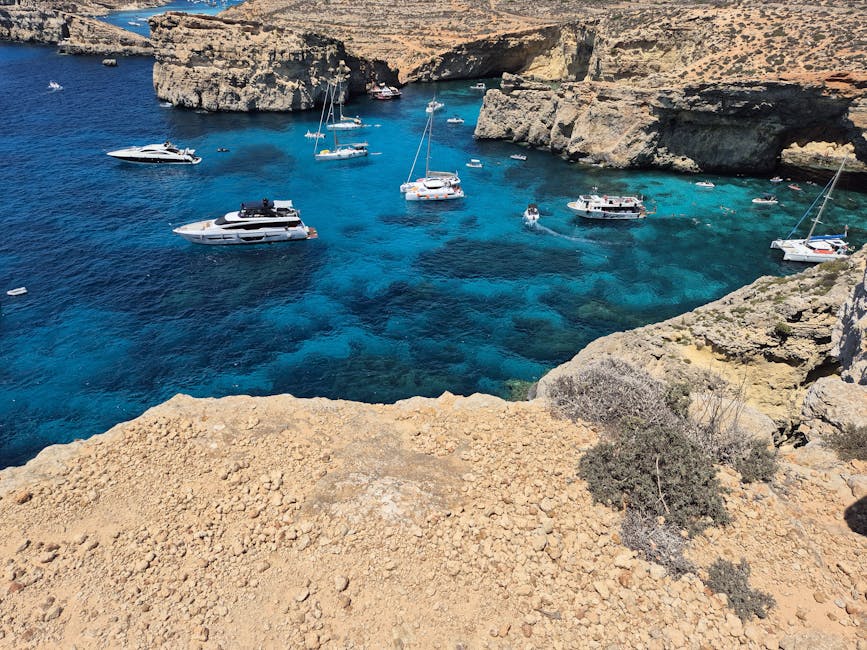 Aerial view of multiple boats anchored in the Blue Lagoon Comino on a calm day