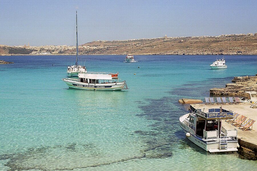 Wide panorama of the Blue Lagoon at Comino with rocky cliffs framing turquoise water