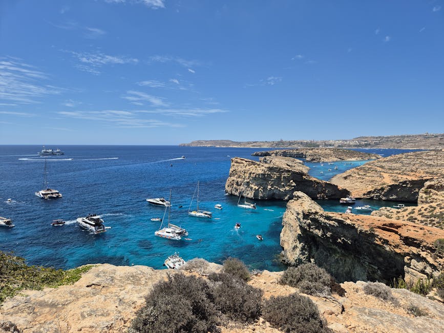 Comino Island coastline with anchored boats and clear blue water