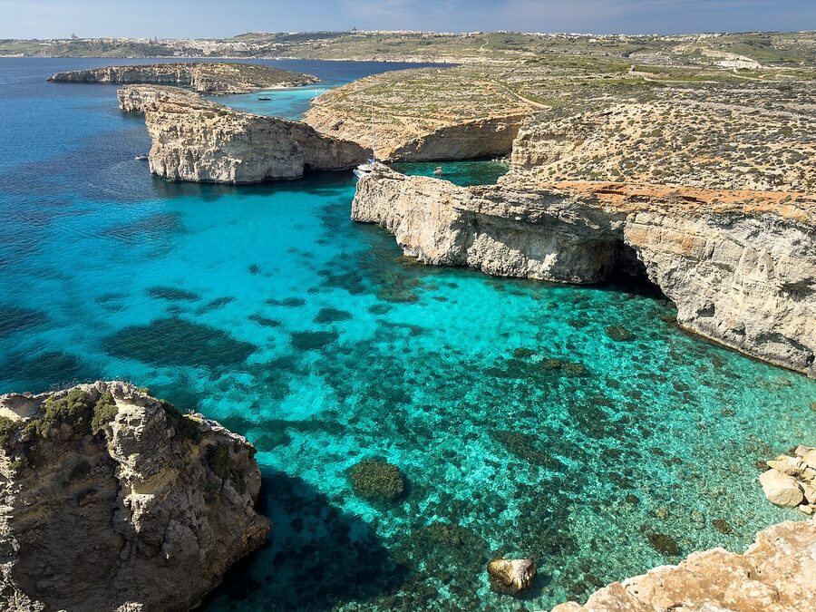 The Crystal Lagoon at Comino with deep blue water and limestone cliffs