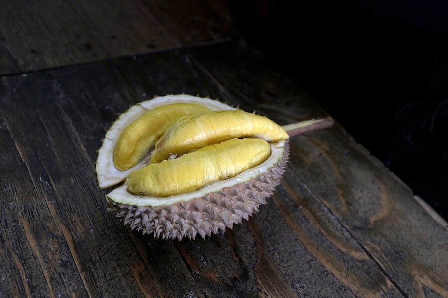 Durian fruit split open showing yellow custard flesh inside