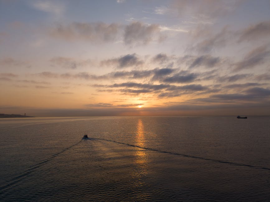 Sunrise over the Spanish coast with a small boat in calm water