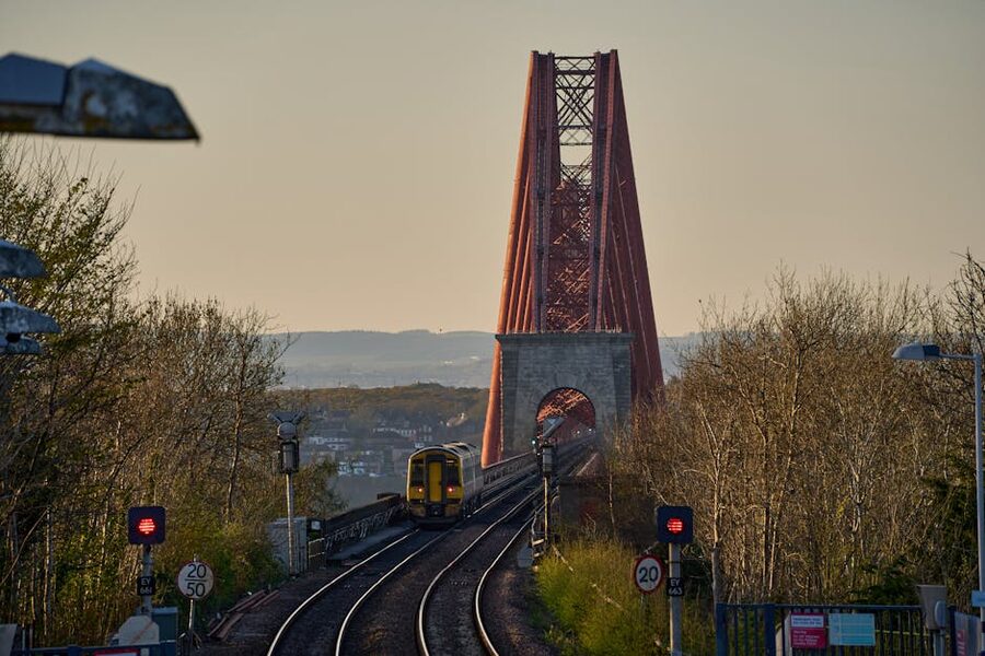 A train crossing the Forth Bridge at dusk in Scotland