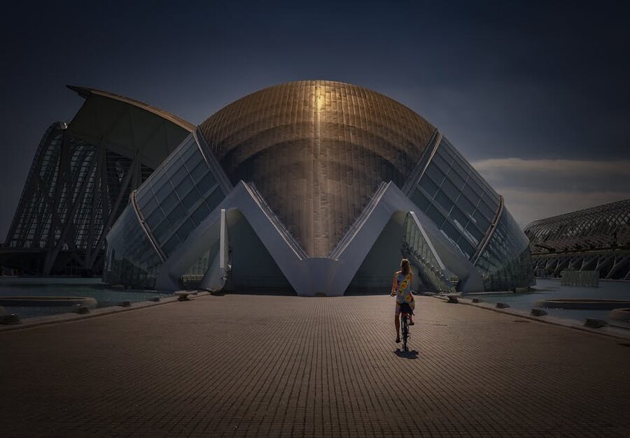 Cyclist riding toward L'Hemisferic Valencia