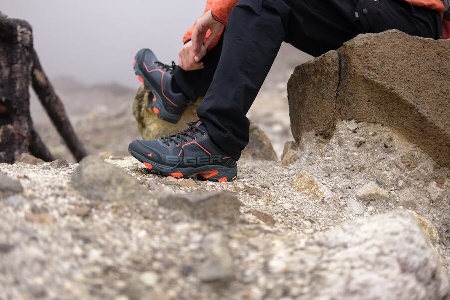Hiker resting on a rock with trekking boots