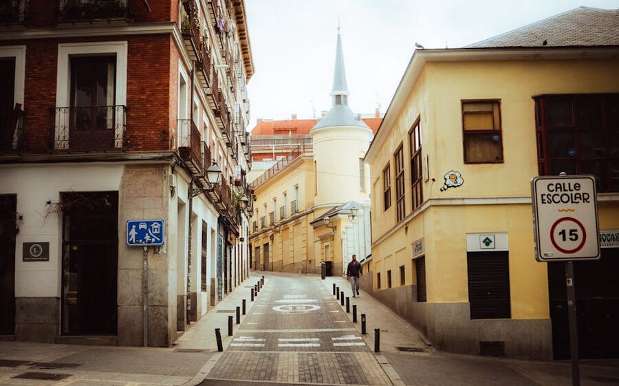 Narrow Madrid La Latina alley with church and historic buildings