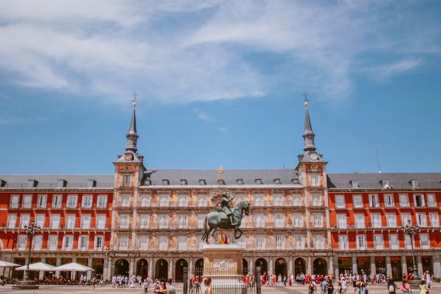 Plaza Mayor Madrid red and white architecture from arched street entrance