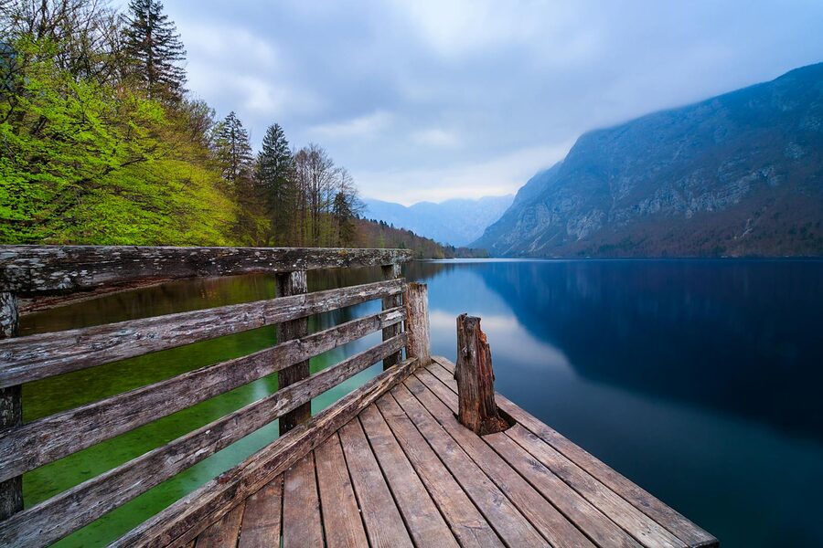 A wooden pier on Lake Bohinj surrounded by mountains