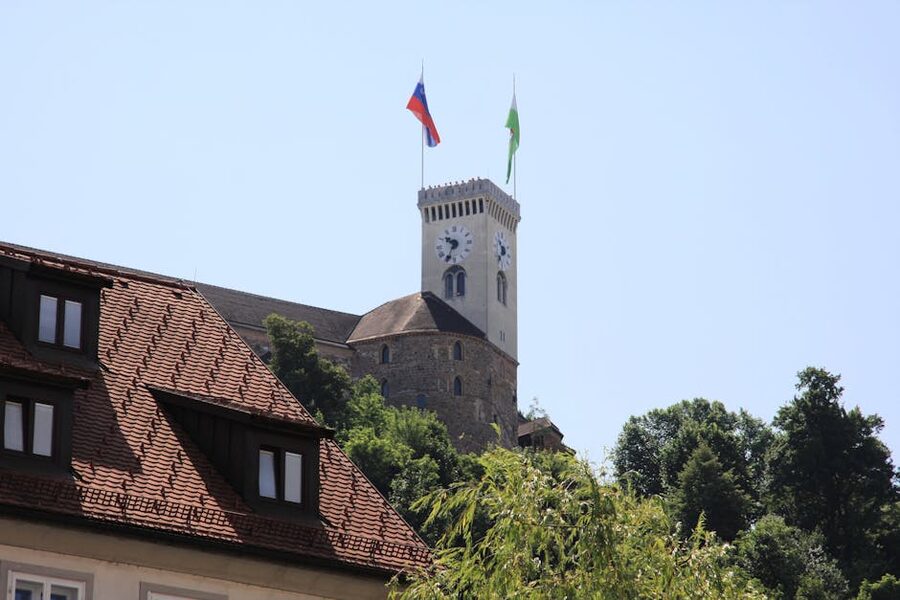 Ljubljana Castle with Slovenian flags flying in summer sun