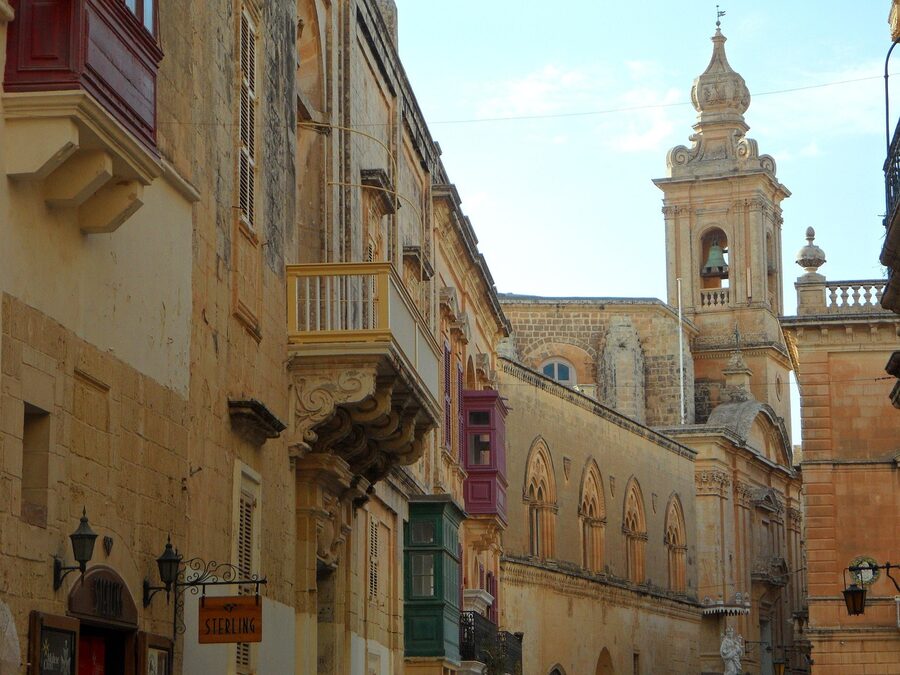Medieval limestone facade with wooden door in Mdina, Malta