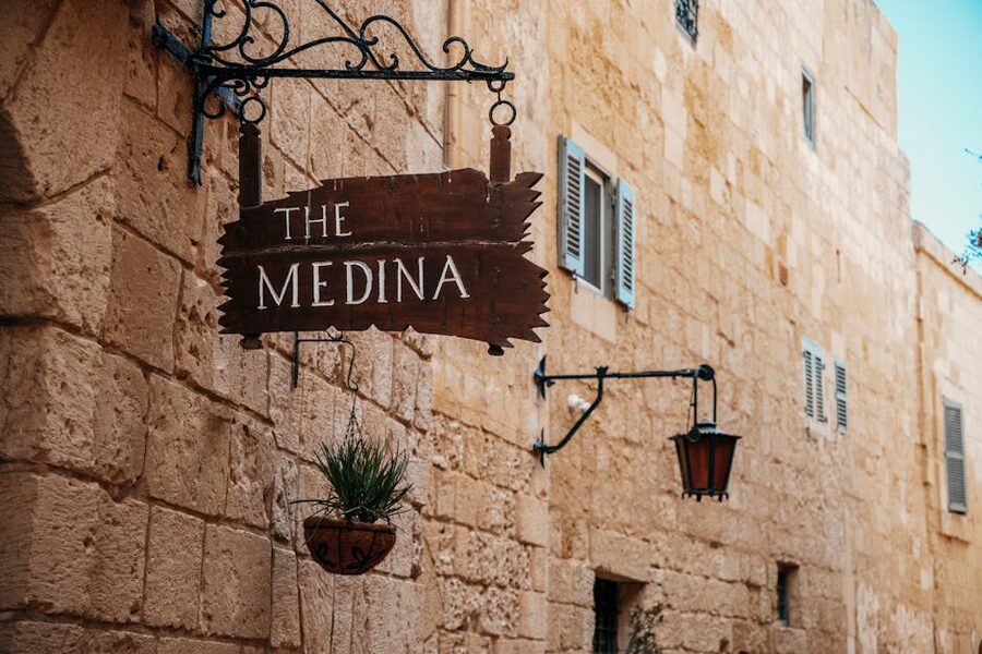 Old medieval medina with rustic Mdina signage on stone wall, Malta
