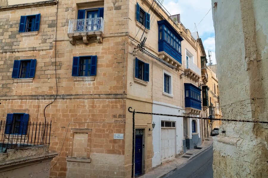 Mdina street with limestone facades and blue painted shutters, Malta