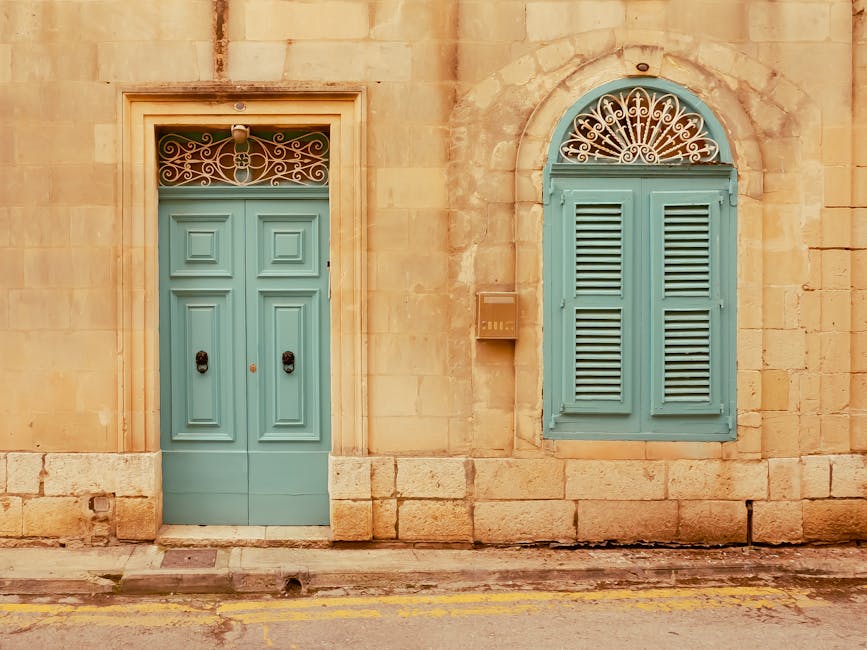 Traditional Maltese teal door and window with decorative ironwork, Mdina