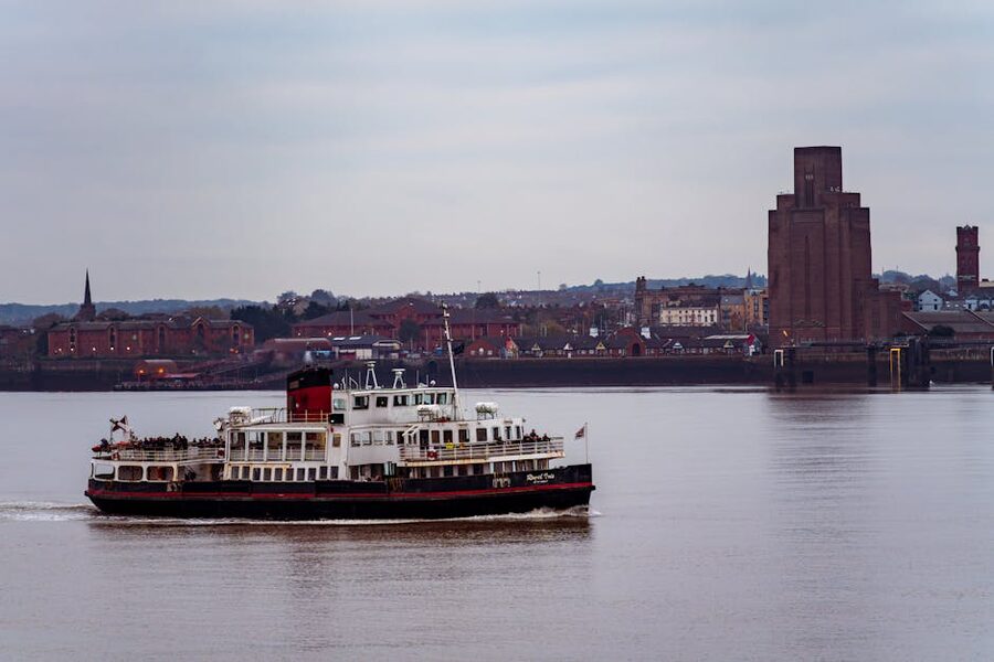 A Mersey ferry sailing on the river with Liverpool landmarks behind
