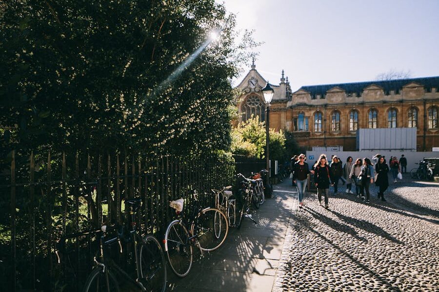 Oxford street with bikes and people walking by historical university buildings