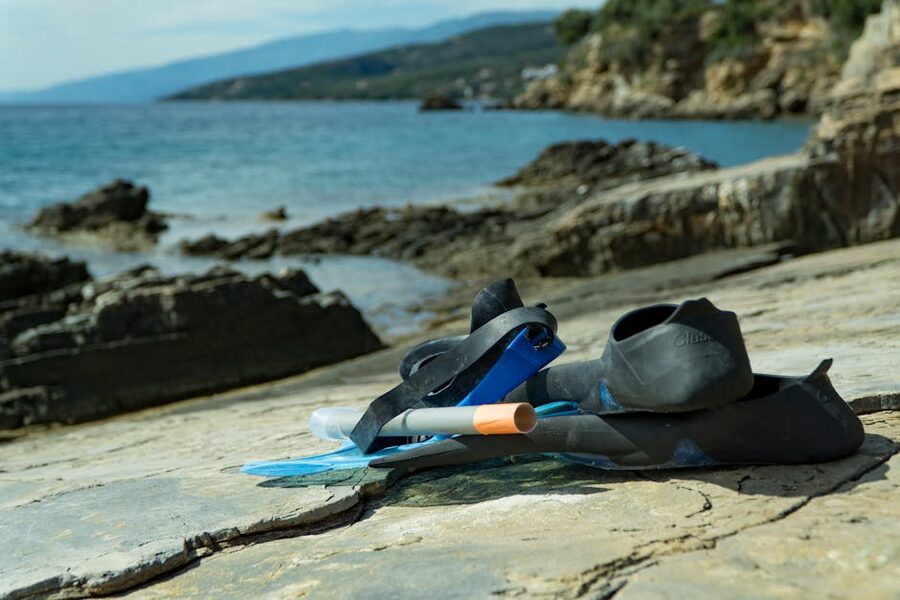Snorkel mask and fins on rocky shore