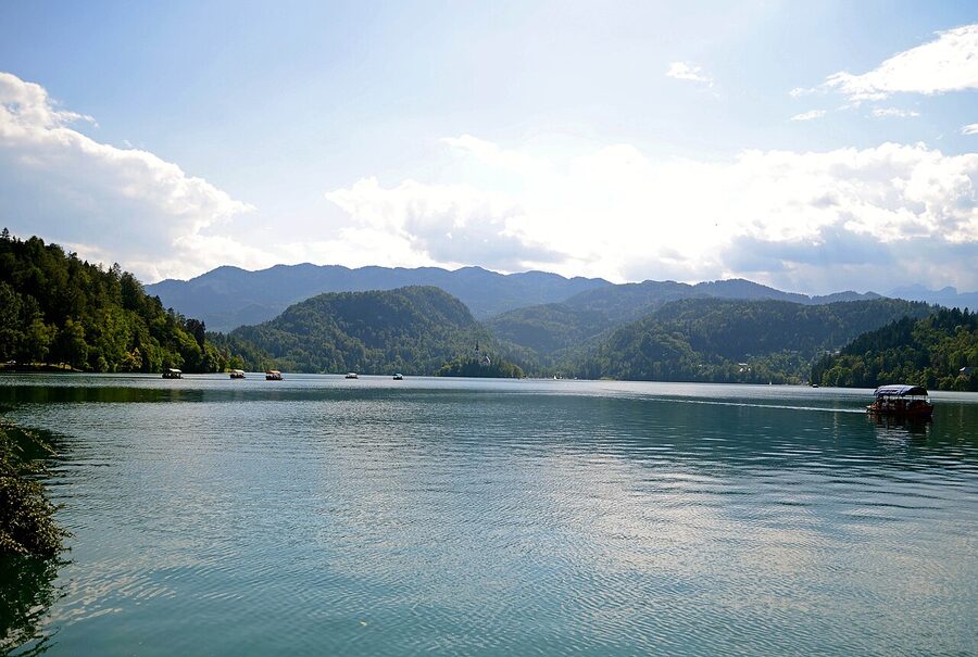 A pletna boat approaches the dock at Bled Island and the Church of the Assumption