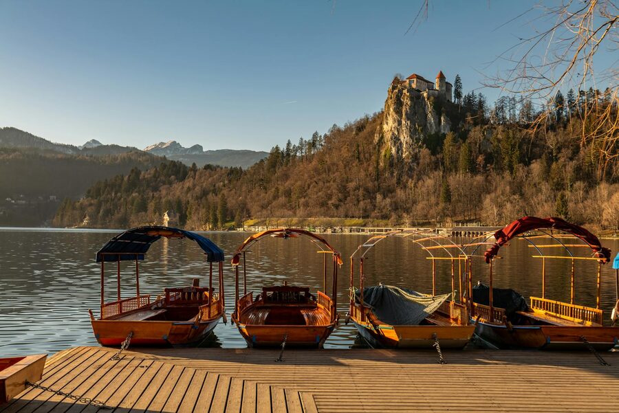 Four pletna boats moored on Lake Bled with Bled Castle behind