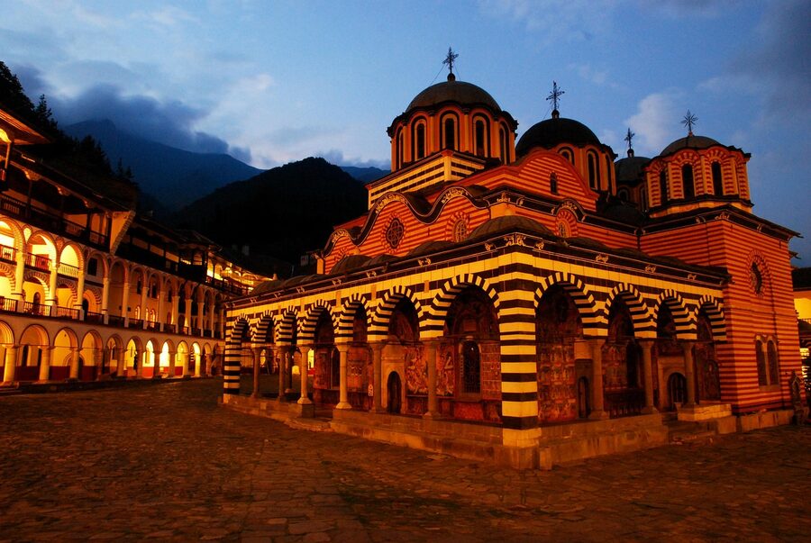 Rila Monastery courtyard illuminated at dusk with deep colour