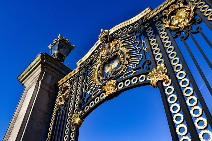 Buckingham Palace ornate gates against blue sky