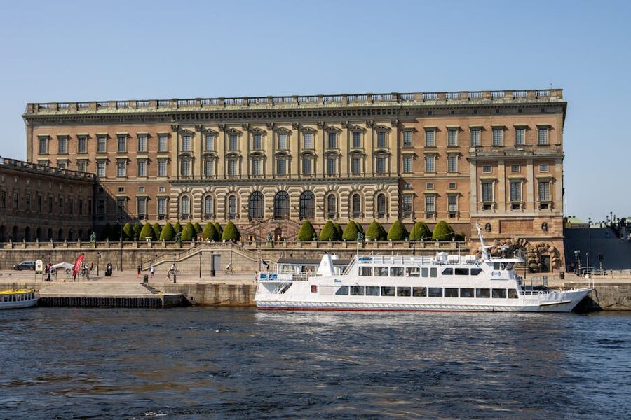 Royal Palace Stockholm with tourist boat passing on the water