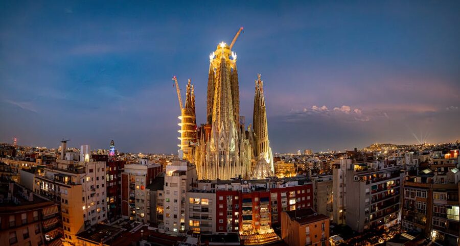 Sagrada Familia illuminated at twilight with the Barcelona cityscape