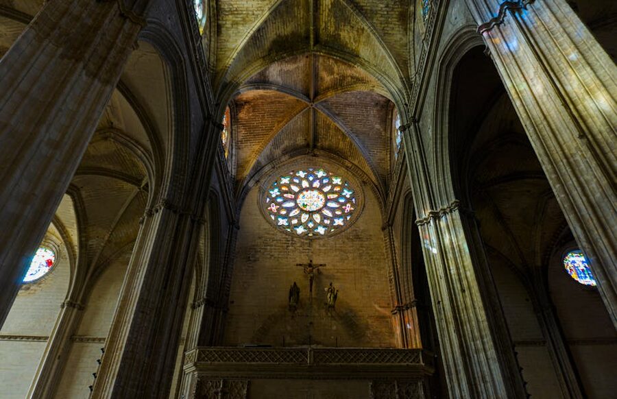 Interior of Seville Cathedral with Gothic vaults and stained glass
