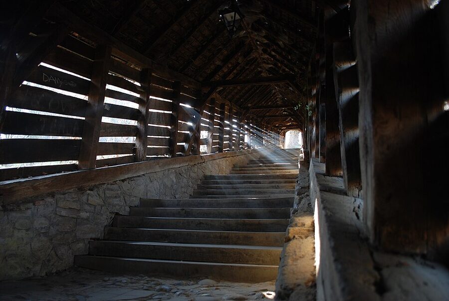 Inside the Sighisoara covered staircase with worn wooden steps and timber roof