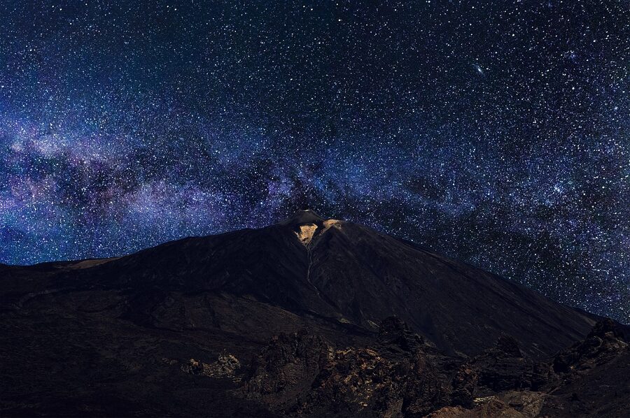 Milky Way arching over Teide volcano with the observatory in the foreground at night