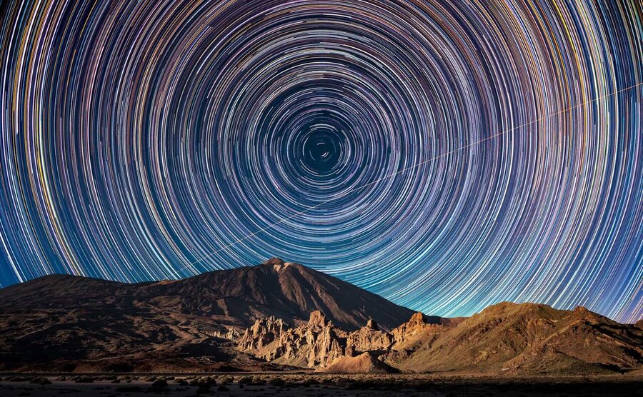 Circumpolar star trails over the Teide volcano with an ISS transit visible