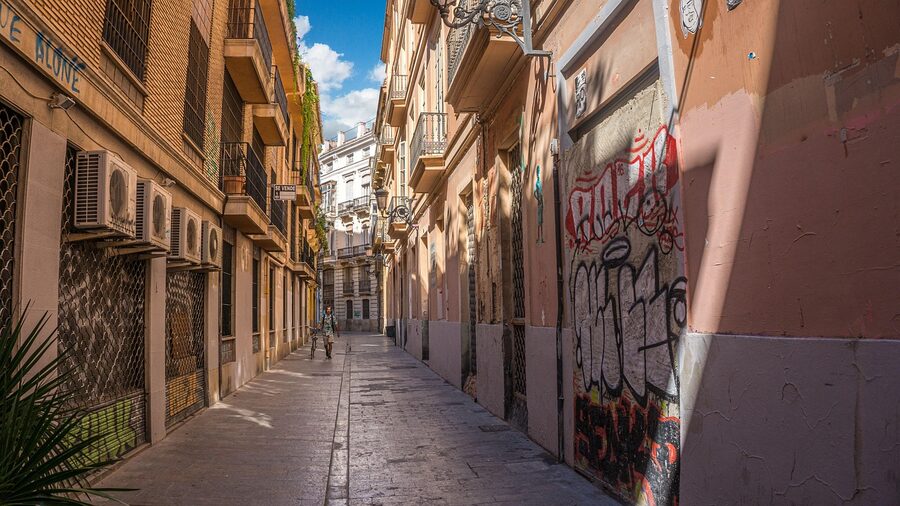 A narrow alley in Valencia's old town under blue sky
