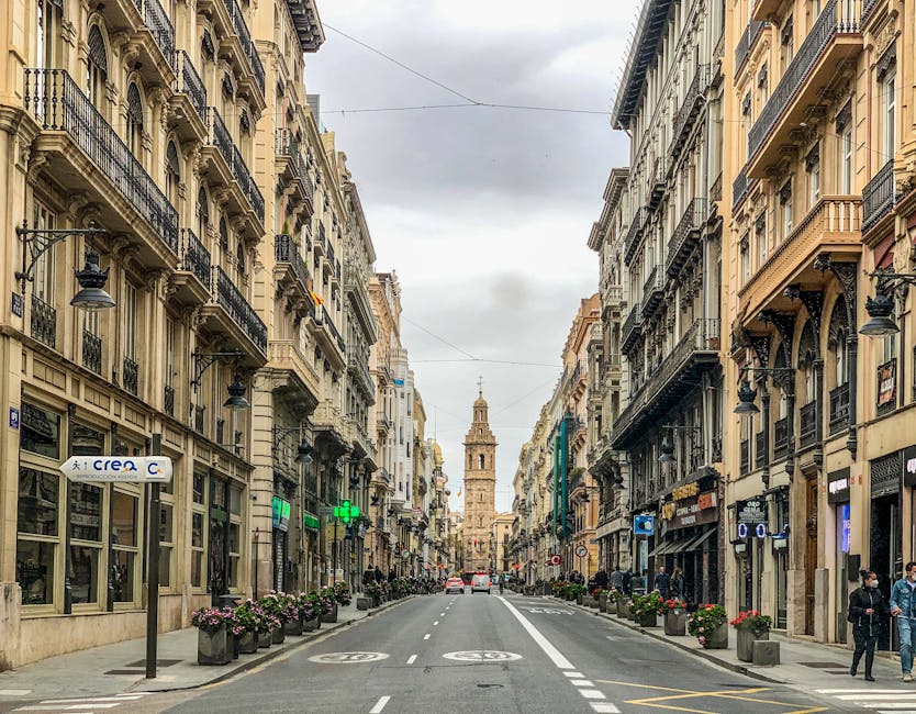 A historic Valencia old town street with the Miguelete bell tower visible